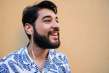 Young man listening to music with earphones.