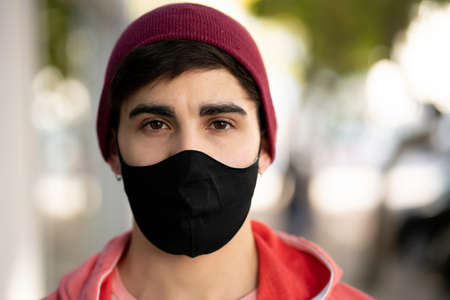 Young man wearing face mask outdoors.の写真素材