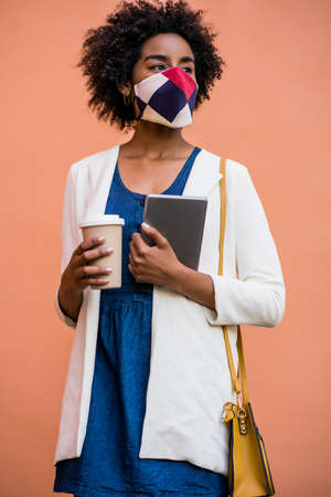 Business woman holding digital tablet and coffee outdoors.