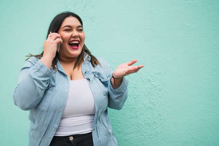 Young plus size woman talking on the phone.の写真素材