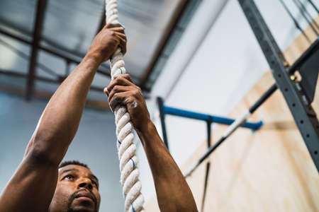 Athletic man doing climbing exercise.