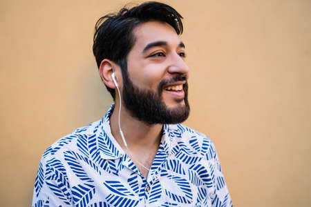 Young man listening to music with earphones.