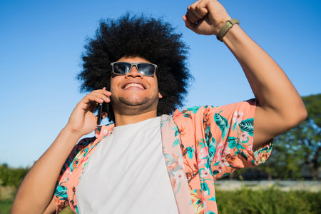 Latin man talking on the phone outdoors.