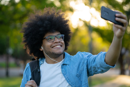 Latin man taking a selfie with phone outdoors.の写真素材