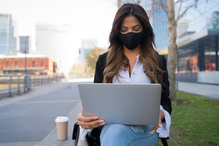 Young woman using her laptop outdoors.の写真素材