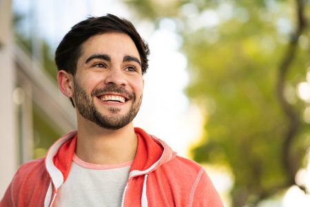 Close-up of young man smiling outdoors.の写真素材