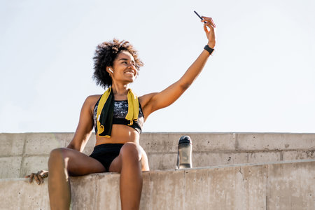 Athlete woman taking a selfie with phone outdoors.