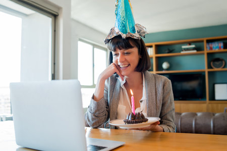 Woman celebrating her birthday online from home.