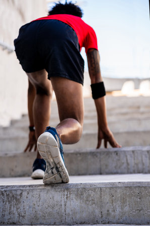 Athlete man in start position preparing to run outdoors.