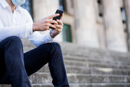 Business man using her mobile phone outdoors.