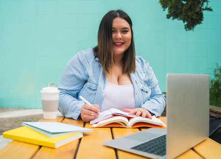 Plus size woman studying at coffee shop.の写真素材
