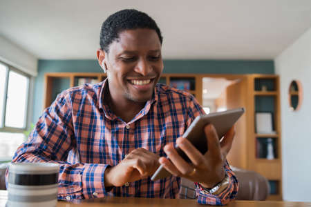Man working from home with tablet.