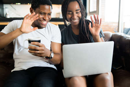 Couple on a video call with laptop at home.