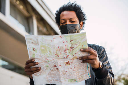 Tourist man looking for directions on map.の写真素材