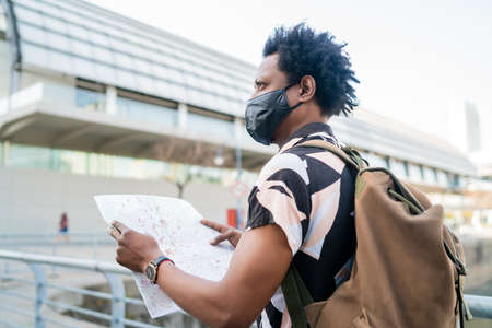 Tourist man looking for directions on map.