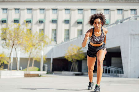 Afro athlete woman running outdoors.の写真素材