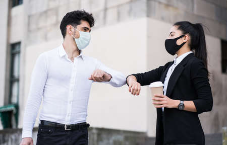 Business people bumping elbows for greeting each other.