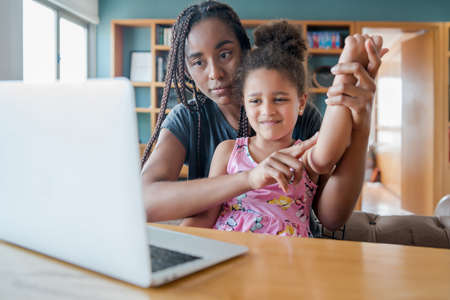 Mother and daughter on a video call with doctor.