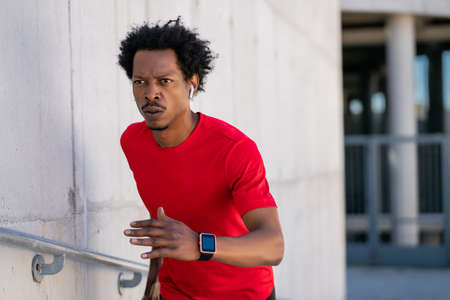 Athletic man running and doing exercise outdoors.