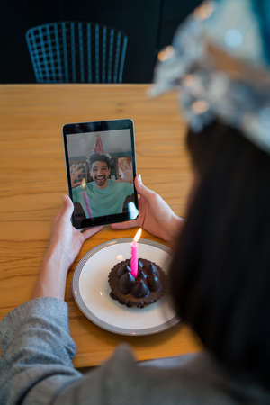 Woman celebrating her birthday on a video call.の写真素材