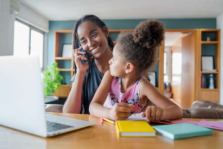A mother helping her daughter with homeschool.の写真素材