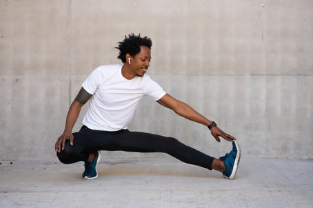 Afro athletic man stretching arms before exercise.の写真素材
