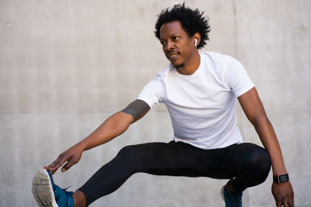 Afro athletic man stretching arms before exercise.の写真素材