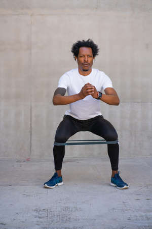 Afro athletic man doing exercise outdoors.の写真素材