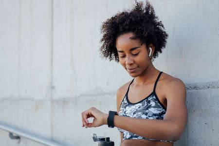 Fitness woman checking time on smart watch.