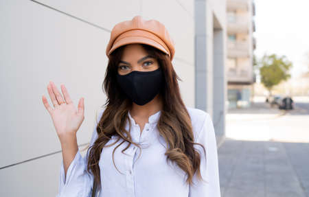 Young woman wearing protective mask outdoors.