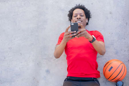 Athletic man using his mobile phone outdoors.