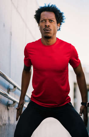 Afro athletic man doing exercise outdoors.の写真素材