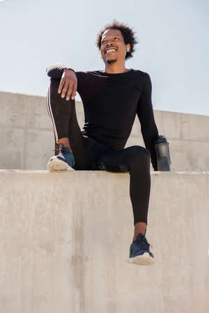 Afro athletic man relaxing after exercise.