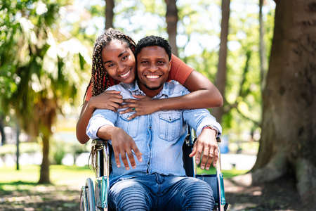 Man in a wheelchair enjoying a walk with his girlfriend.の写真素材