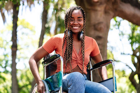 Woman in wheelchair listening music with headphones.