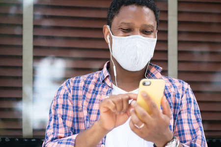 Man using his phone on the street.