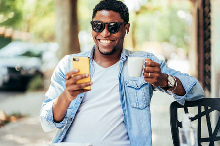 Man on a video call with a mobile phone at coffee shop.の写真素材