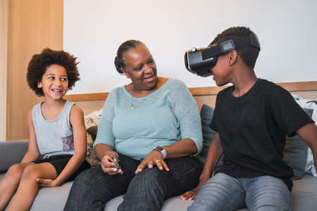 Grandmother and grandchildren playing together with VR glasses.の写真素材