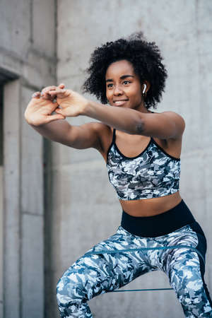 Afro athletic woman doing exercise outdoors.
