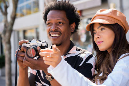 Tourist couple using camera outdoors.の写真素材