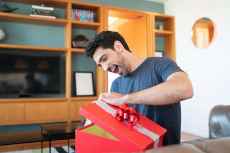 Surprised man opening a gift box.の写真素材