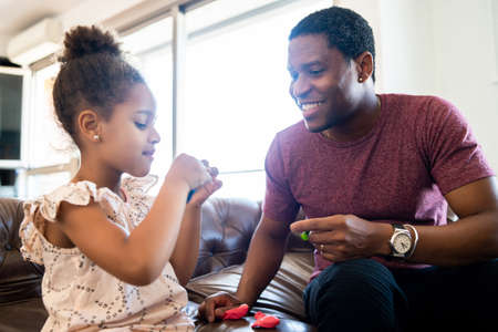 Daughter and father playing together at home.の写真素材