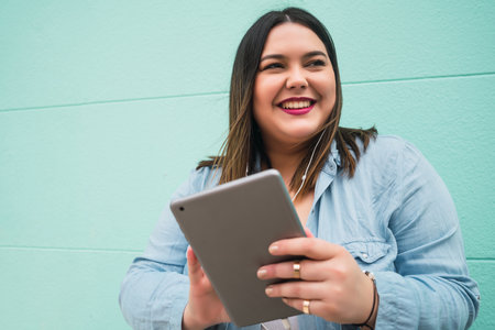 Young woman listening music with earphones and tablet.の写真素材