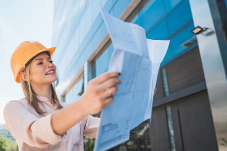 Professional architect holding blueprints outdoors.の写真素材