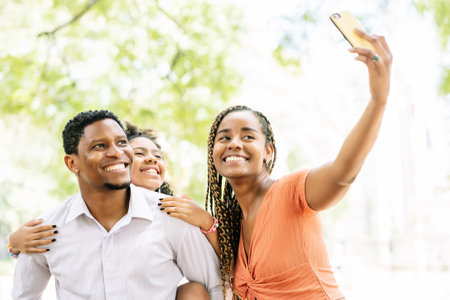 Family taking a selfie with a mobile phone at the park.の写真素材