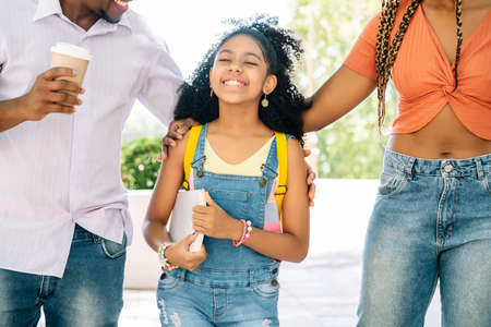 Little girl going to the school with her parents.の写真素材