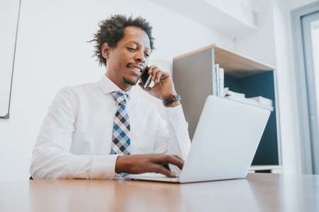 Businessman talking on phone at office.