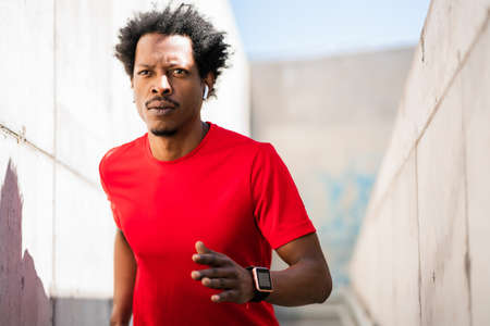 Athletic man running and doing exercise outdoors.の写真素材