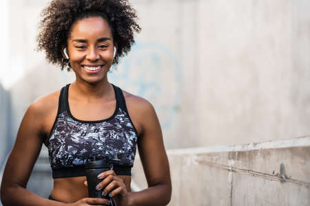 Afro athlete woman holding a bottle of water.の写真素材