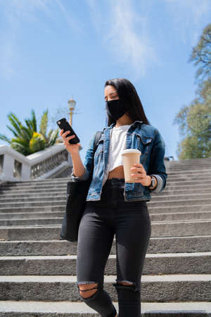 Young woman using her mobile phone outdoors.の写真素材